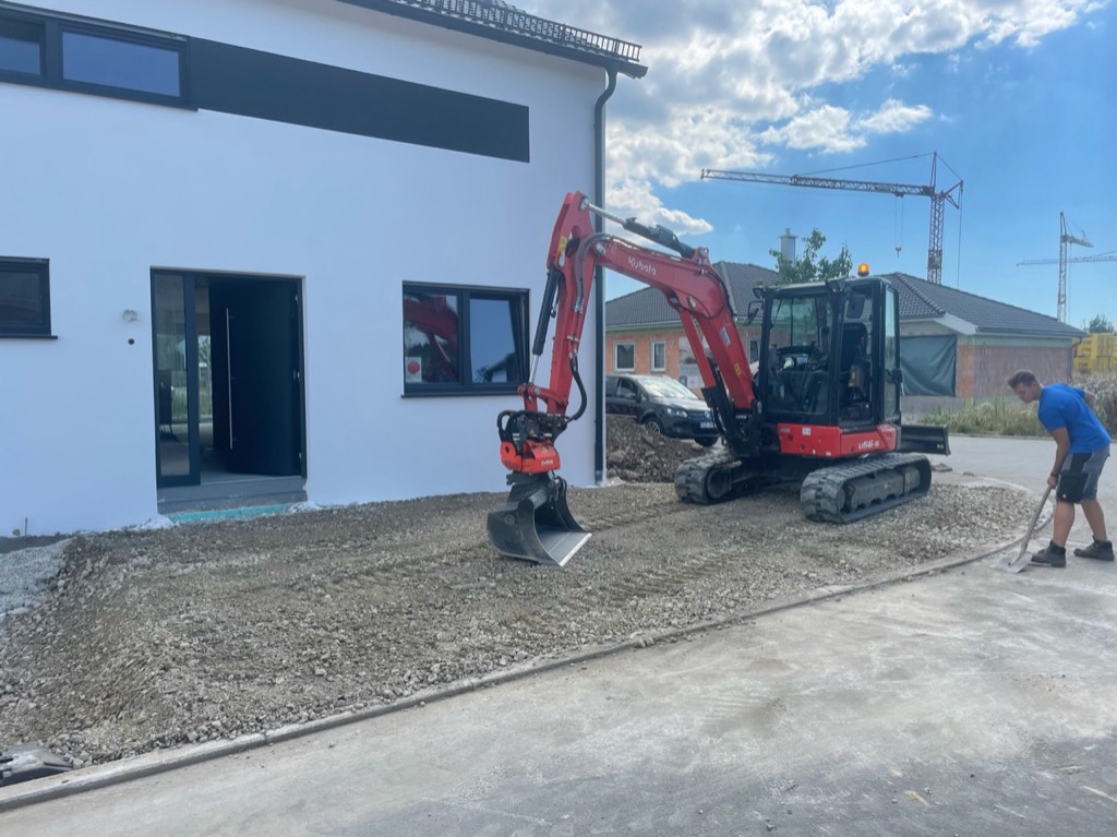 Hofeinfahrt mit Minibagger an Einfamilienhaus